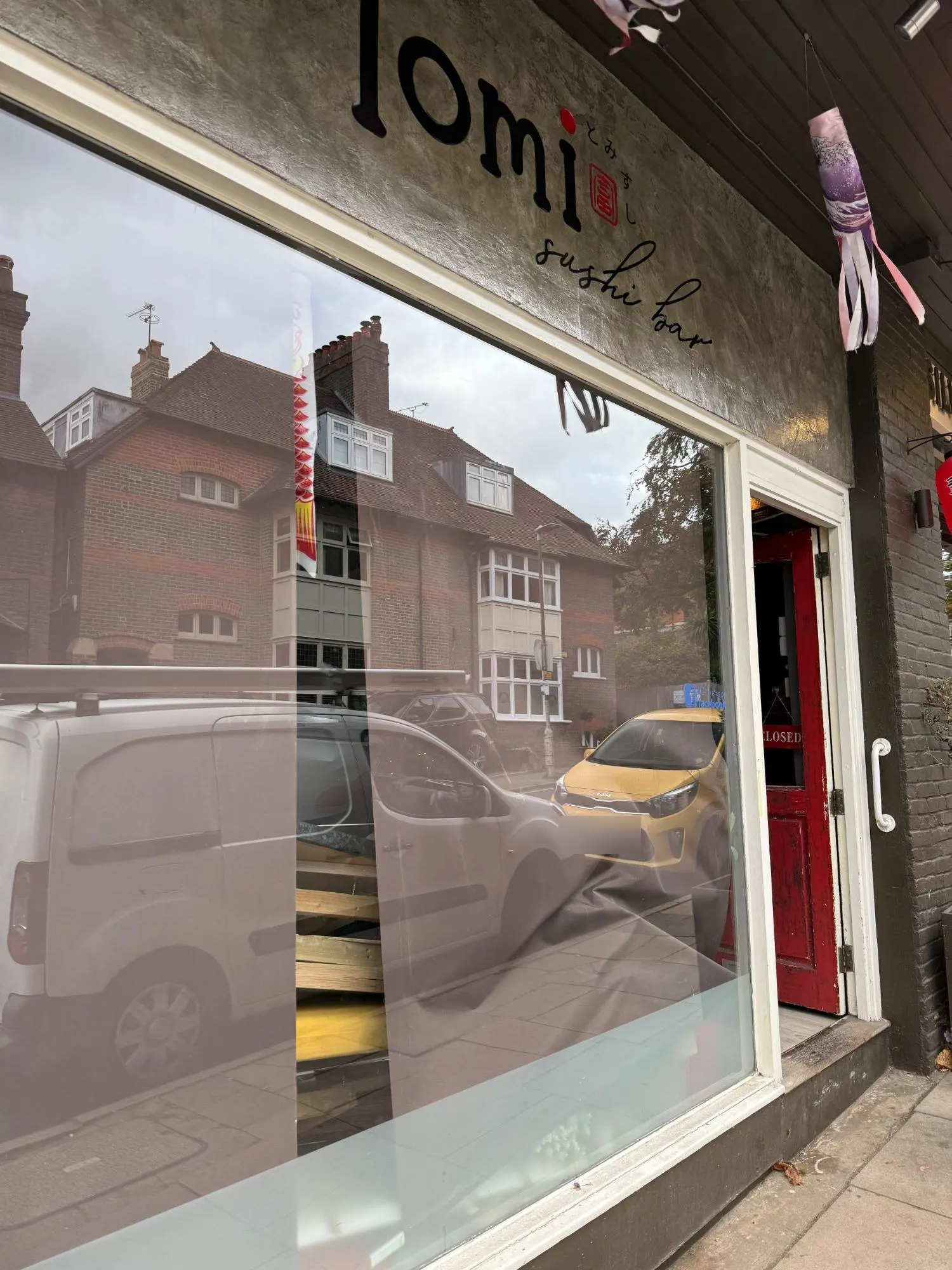 The Tomi Sushi Bar shopfront on Vaughan Road, with its sign still above the window, a red door propped open and a Closed sign hanging inside